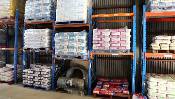 Pallets of cement, concrete mix and mortar on the racks in the shed